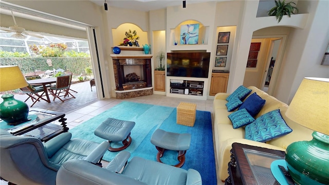 8596 SW Riverside Dr, Arcadia, FL 34269 - living area featuring tile patterned floors, a ceiling fan, a high end fireplace, and arched walkways