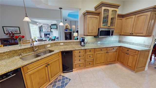 8596 SW Riverside Dr, Arcadia, FL 34269 - kitchen featuring a sink, dishwasher, a fireplace, stainless steel microwave, and light stone counters