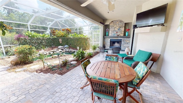 8596 SW Riverside Dr, Arcadia, FL 34269 - view of patio featuring an outdoor stone fireplace, a ceiling fan, outdoor dining area, and glass enclosure