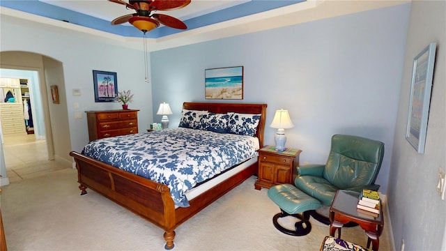 8596 SW Riverside Dr, Arcadia, FL 34269 - bedroom featuring arched walkways, light carpet, a ceiling fan, and baseboards
