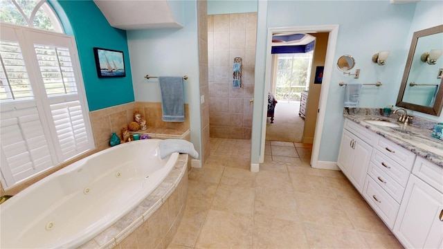 8596 SW Riverside Dr, Arcadia, FL 34269 - bathroom featuring vanity, tile patterned flooring, a jetted tub, a walk in shower, and baseboards
