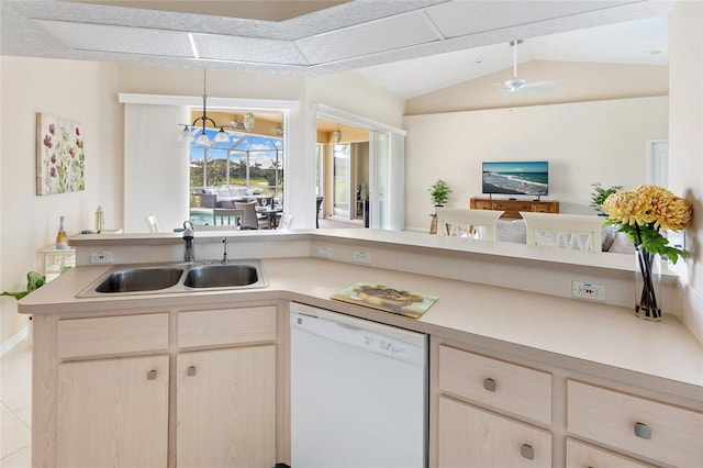 kitchen featuring white dishwasher, a sink, light countertops, and lofted ceiling
