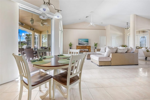 dining space with a ceiling fan, vaulted ceiling, plenty of natural light, and light tile patterned floors