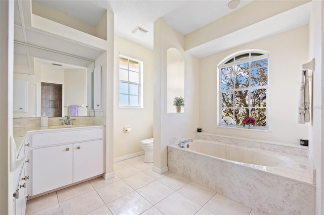 bathroom with toilet, vanity, tile patterned floors, a garden tub, and baseboards