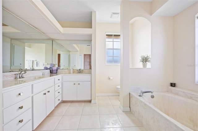 full bathroom featuring toilet, double vanity, a garden tub, tile patterned floors, and baseboards