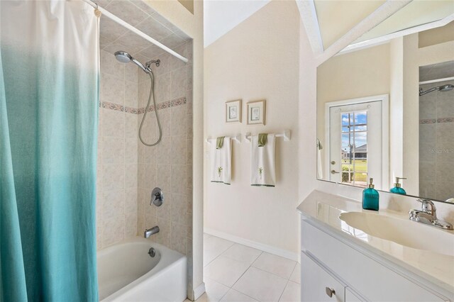 bathroom featuring tile patterned flooring, shower / tub combo, vanity, and baseboards