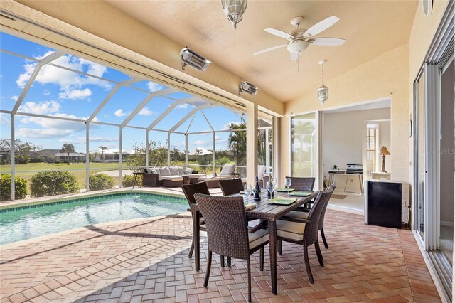 swimming pool featuring an outdoor hangout area, a patio, a ceiling fan, and glass enclosure