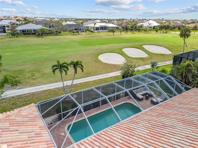swimming pool with a residential view, glass enclosure, golf course view, and a yard