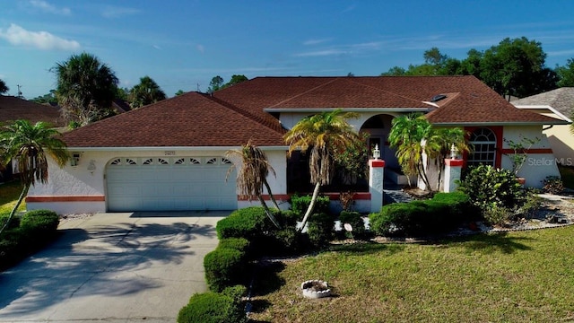 view of front of house featuring an attached garage, driveway, stucco siding, and a front lawn