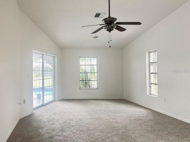 carpeted spare room featuring vaulted ceiling, healthy amount of natural light, ceiling fan, and baseboards