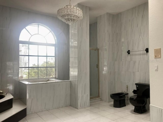 bathroom with a shower stall, tile walls, a garden tub, a chandelier, and a bidet