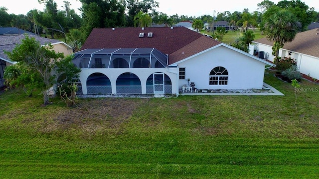 rear view of property with cooling unit, a lawn, glass enclosure, and stucco siding