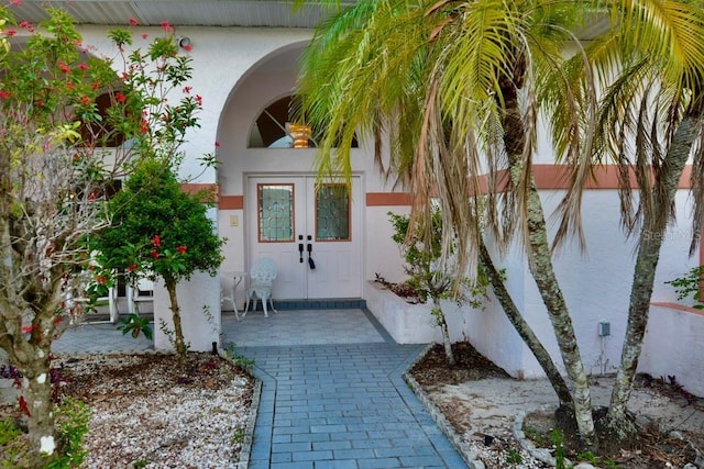 doorway to property featuring stucco siding and french doors