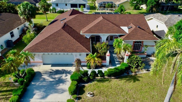 view of front of home with concrete driveway, roof with shingles, an attached garage, and a residential view
