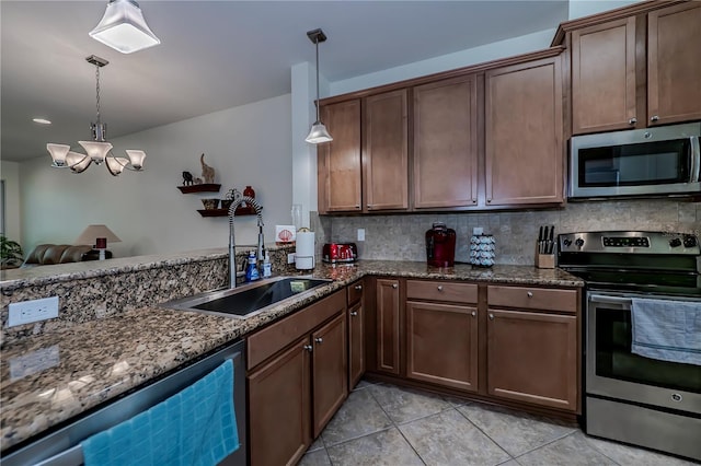 15050 Sandpiper Preserve Blvd Unit 101, Fort Myers, FL 33919 - kitchen featuring a sink, tasteful backsplash, dark stone countertops, a notable chandelier, and appliances with stainless steel finishes