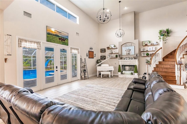 7192 SW Albritton St, Arcadia, FL 34266 - living area with a towering ceiling, a chandelier, wood finished floors, french doors, and stairs
