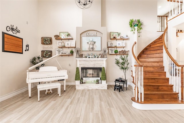 7192 SW Albritton St, Arcadia, FL 34266 - living room featuring a high ceiling, stairs, a fireplace, wood finished floors, and baseboards