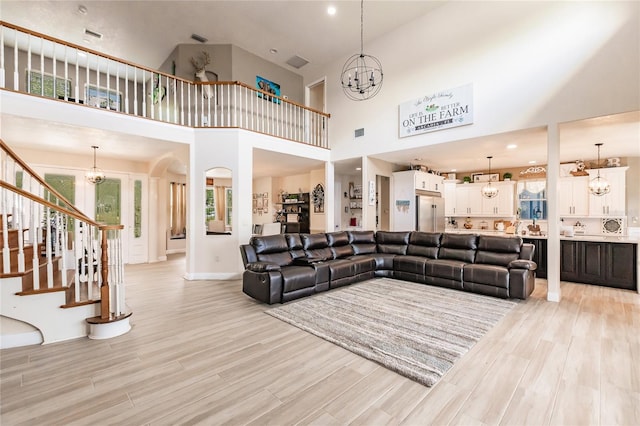 7192 SW Albritton St, Arcadia, FL 34266 - living area with a chandelier, a high ceiling, stairway, light wood-type flooring, and baseboards