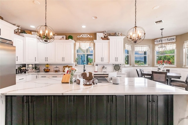 7192 SW Albritton St, Arcadia, FL 34266 - kitchen with a chandelier, white cabinets, a large island, tasteful backsplash, and recessed lighting
