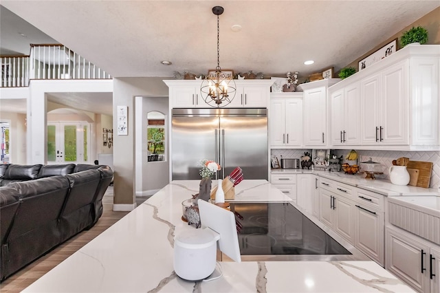 7192 SW Albritton St, Arcadia, FL 34266 - kitchen with stainless steel built in fridge, open floor plan, tasteful backsplash, a chandelier, and white cabinetry