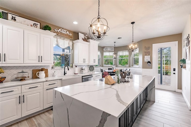 7192 SW Albritton St, Arcadia, FL 34266 - kitchen featuring a chandelier, stainless steel dishwasher, a sink, white cabinetry, and a center island