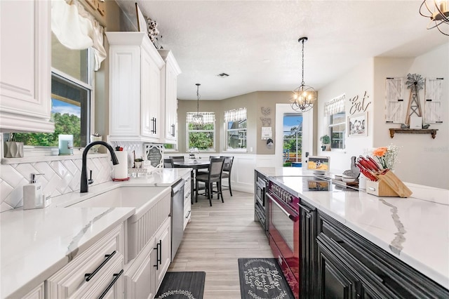 7192 SW Albritton St, Arcadia, FL 34266 - kitchen featuring appliances with stainless steel finishes, a chandelier, white cabinetry, pendant lighting, and light wood-style flooring