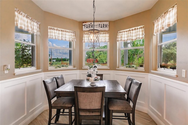 7192 SW Albritton St, Arcadia, FL 34266 - dining area with a decorative wall, a chandelier, light wood-type flooring, and a wainscoted wall