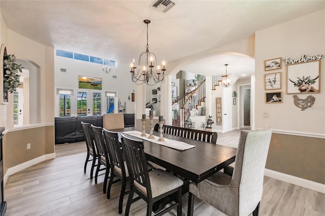 7192 SW Albritton St, Arcadia, FL 34266 - dining room featuring a chandelier, light wood-type flooring, arched walkways, and stairs