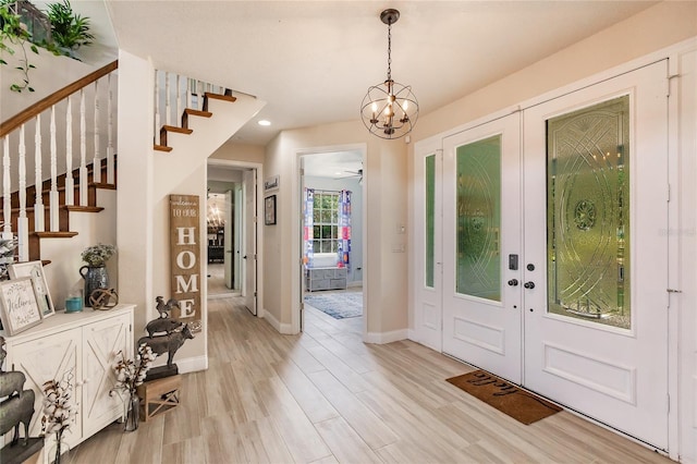 7192 SW Albritton St, Arcadia, FL 34266 - entryway with french doors, stairs, light wood-style floors, a chandelier, and baseboards