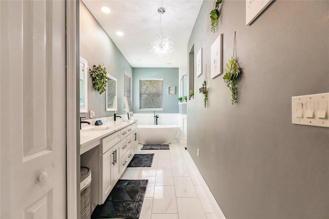 7192 SW Albritton St, Arcadia, FL 34266 - bathroom featuring a freestanding bath, double vanity, a chandelier, and recessed lighting