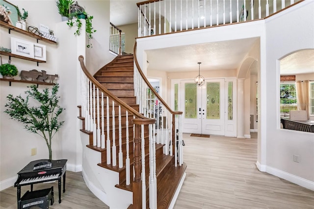 7192 SW Albritton St, Arcadia, FL 34266 - entryway featuring arched walkways, baseboards, light wood finished floors, and stairway