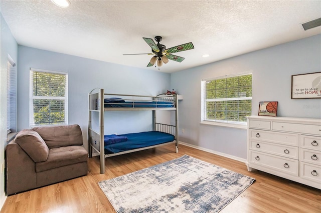 7192 SW Albritton St, Arcadia, FL 34266 - bedroom with multiple windows, light wood-type flooring, a textured ceiling, ceiling fan, and baseboards