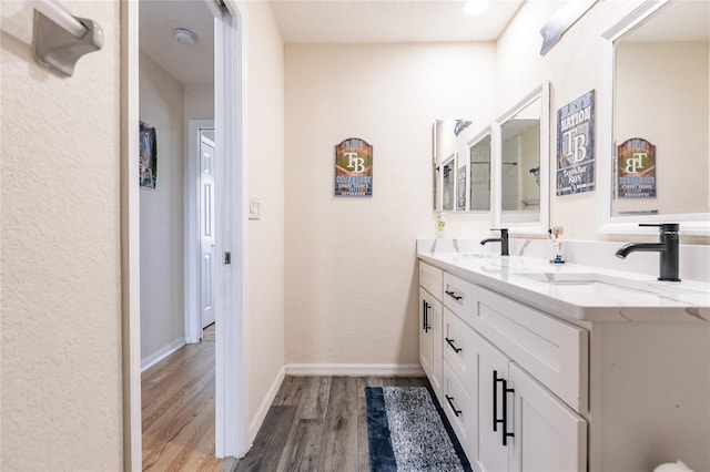 7192 SW Albritton St, Arcadia, FL 34266 - full bathroom featuring wood finished floors, double vanity, baseboards, and a textured wall