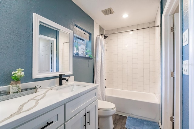 7192 SW Albritton St, Arcadia, FL 34266 - full bathroom with vanity, a textured wall, toilet, wood finished floors, and shower / tub combo