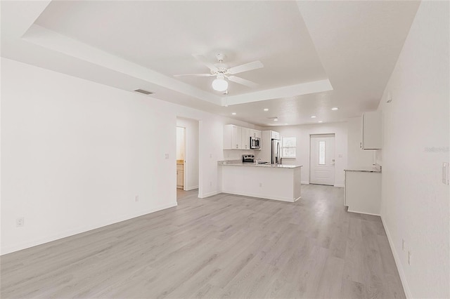 27438 Corinthian Dr, Punta Gorda, FL 33955 - unfurnished living room with a raised ceiling, a ceiling fan, light wood finished floors, baseboards, and recessed lighting