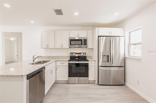 27438 Corinthian Dr, Punta Gorda, FL 33955 - kitchen featuring stainless steel appliances, a sink, a peninsula, light wood-style flooring, and light stone counters