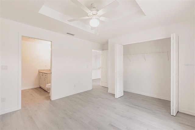 27438 Corinthian Dr, Punta Gorda, FL 33955 - unfurnished bedroom with light wood finished floors, a tray ceiling, a closet, and baseboards