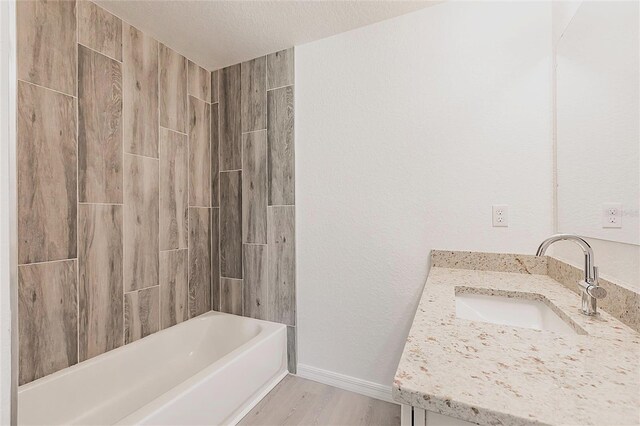 27438 Corinthian Dr, Punta Gorda, FL 33955 - full bathroom featuring wood finished floors, vanity, shower / bathtub combination, and baseboards