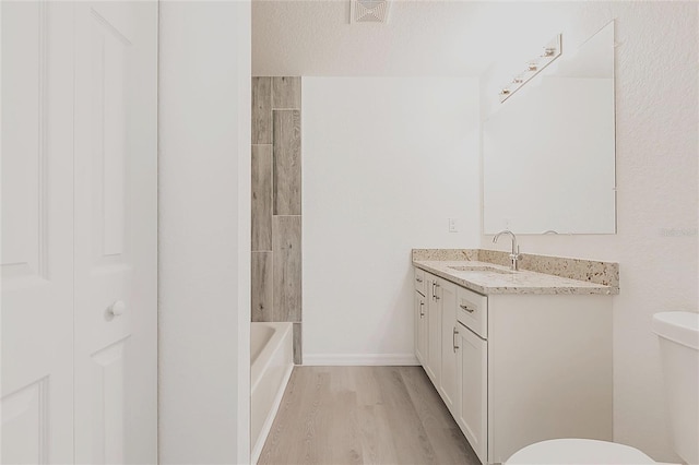 27438 Corinthian Dr, Punta Gorda, FL 33955 - bathroom with toilet, wood finished floors, vanity, baseboards, and a textured ceiling