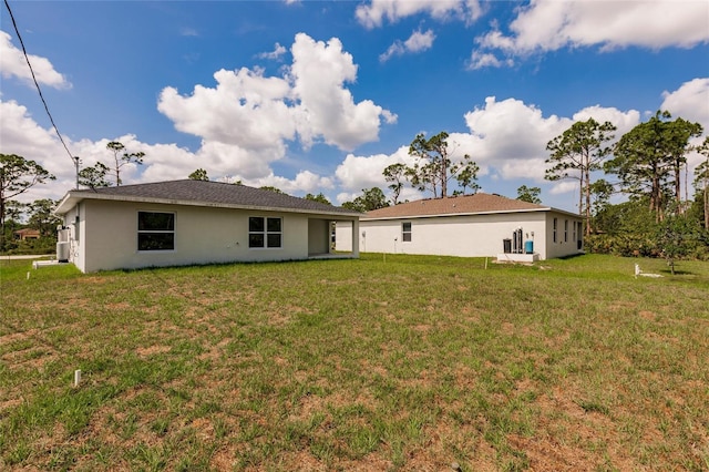 27438 Corinthian Dr, Punta Gorda, FL 33955 - rear view of property featuring stucco siding and a yard