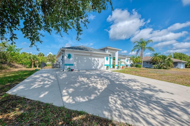 3027 Ridgewood Dr, North Port, FL 34287 - view of side of property featuring an attached garage, concrete driveway, and a gate