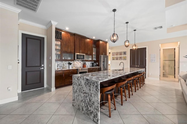 3527 NW 8th Ter, Cape Coral, FL 33993 - kitchen with stainless steel appliances, light tile patterned floors, backsplash, a breakfast bar area, and ornamental molding