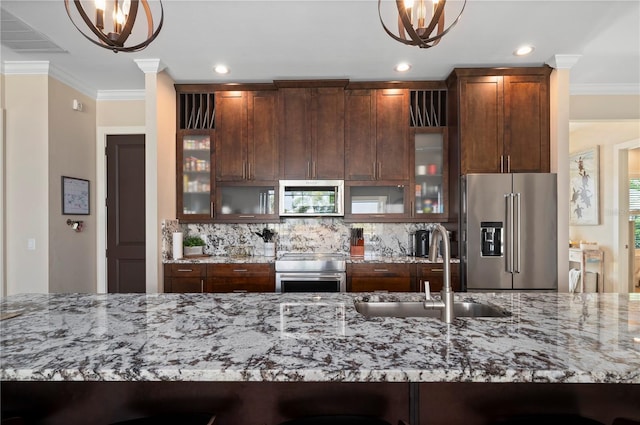 3527 NW 8th Ter, Cape Coral, FL 33993 - kitchen featuring appliances with stainless steel finishes, decorative backsplash, crown molding, a chandelier, and light stone countertops