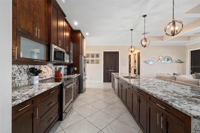 3527 NW 8th Ter, Cape Coral, FL 33993 - kitchen featuring appliances with stainless steel finishes, tasteful backsplash, light stone counters, hanging light fixtures, and dark brown cabinets