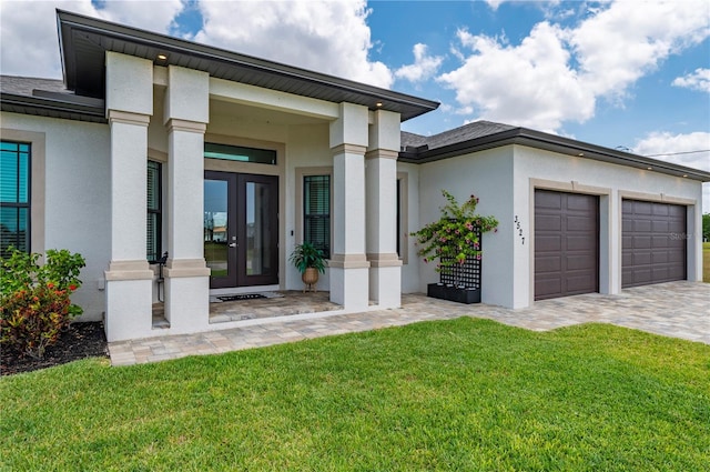 3527 NW 8th Ter, Cape Coral, FL 33993 - view of exterior entry with french doors, stucco siding, a garage, a yard, and decorative driveway