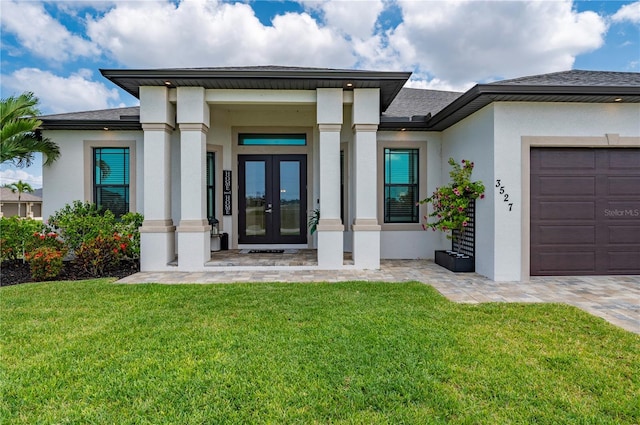 3527 NW 8th Ter, Cape Coral, FL 33993 - view of exterior entry with french doors, stucco siding, a garage, a lawn, and a shingled roof