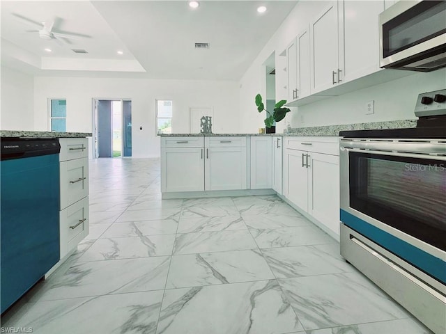 kitchen with appliances with stainless steel finishes, recessed lighting, light stone countertops, white cabinets, and a peninsula