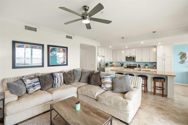 living area with ornamental molding, ceiling fan, recessed lighting, baseboards, and light tile patterned floors