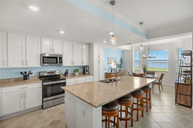 kitchen featuring stainless steel appliances, a sink, white cabinetry, crown molding, and light tile patterned flooring