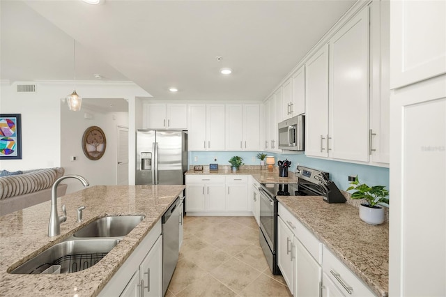 kitchen featuring appliances with stainless steel finishes, a sink, white cabinets, recessed lighting, and hanging light fixtures
